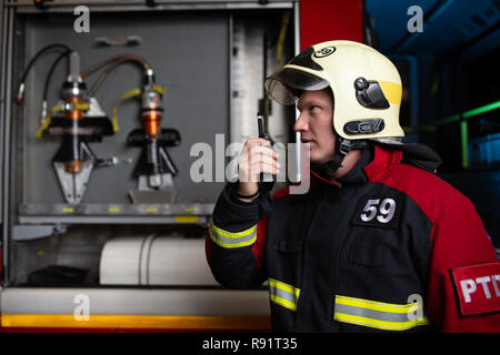 Bild der männlichen Feuerwehrmann in Helm mit walkie-talkie Stockfoto