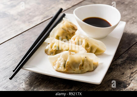 Knödel oder Gyoza und Sojasauce auf hölzernen Tisch Stockfoto