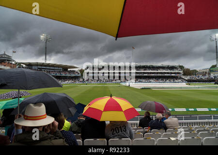 MCC-Regenschirm in den markanten Speck und Ei Farbschema Tierheim Zuschauer aus ein heftiger Platzregen während des England 2018 v Indien Test Match Stockfoto