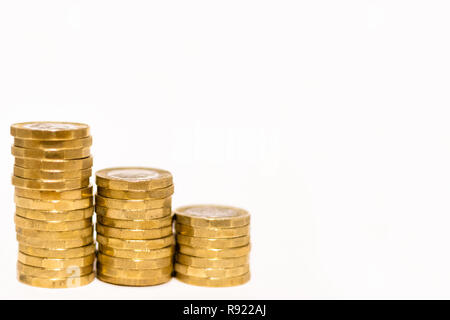 Stapel und Haufen von Britischen GBP goldenen Münzen Währung Geld auf weißem Hintergrund mit leeren Raum Stockfoto