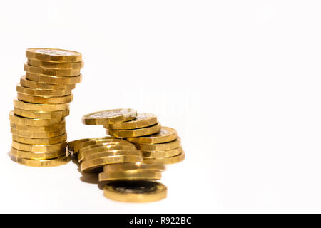Stapel und Haufen von Britischen GBP goldenen Münzen Währung Geld auf weißem Hintergrund mit leeren Raum Stockfoto