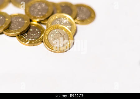 Stapel und Haufen von Britischen GBP goldenen Münzen Währung Geld auf weißem Hintergrund mit leeren Raum Stockfoto