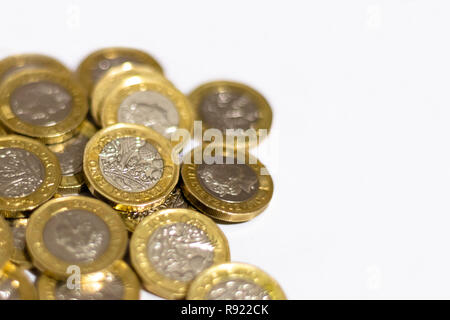 Stapel und Haufen von Britischen GBP goldenen Münzen Währung Geld auf weißem Hintergrund mit leeren Raum Stockfoto