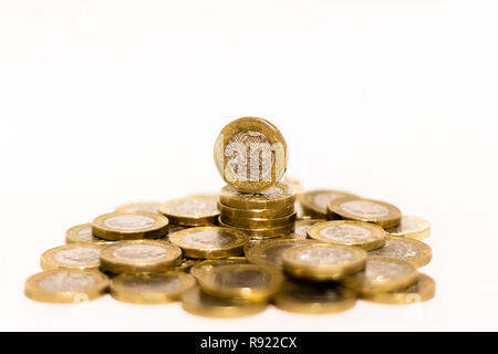 Stapel und Haufen von Britischen GBP goldenen Münzen Währung Geld auf weißem Hintergrund mit leeren Raum Stockfoto