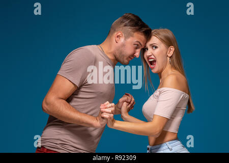 Profil Seitenansicht Portrait von wütenden Mann und Frau in der lässigen Stil stehen, suchen und Schreien an einander. Stockfoto