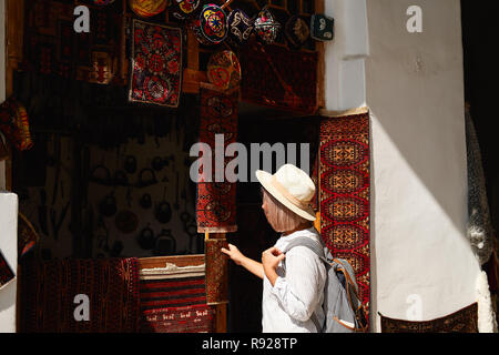 Buchara, Usbekistan 1. September Frau kaufen Andenken. Gerne weibliche Person Einkaufen in Asien exotischen Shop reisen, haben Spaß Stockfoto