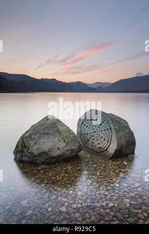 Das Millenium Stein in die Untiefen des Derwent Water in der Nähe von Keswick mit Blick in Richtung Borrowdale an einem kalten, klaren Morgen ist Winter im Lake District. Stockfoto