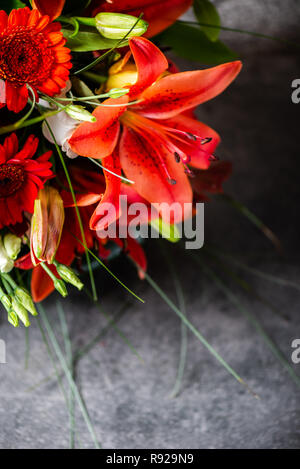 Lebendige Blumenstrauß aus verschiedenen Blumen wie orange Asiatische Lilien, inkalilie, Germinis, gelbe Rosen und Chrysanthemen Stockfoto