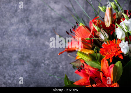 Lebendige Blumenstrauß aus verschiedenen Blumen wie orange Asiatische Lilien, inkalilie, Germinis, gelbe Rosen und Chrysanthemen Stockfoto