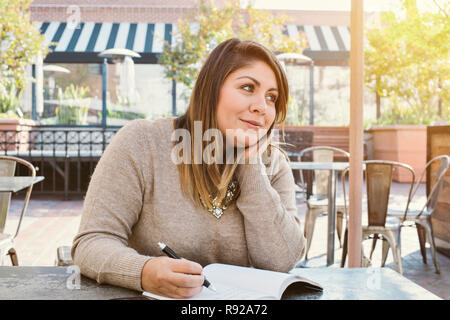 Blick auf junge Latina in Bestrebungen und schreiben Sie Ihre Ziele Stockfoto