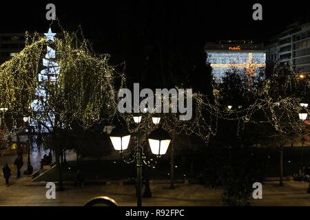 Athen, Griechenland. 18 Dez, 2018. Menschen gehen um einen beleuchteten Weihnachtsbaum auf dem Syntagma-Platz in Athen. (Bild: © aristidis VafeiadakisZUMA Draht) Stockfoto