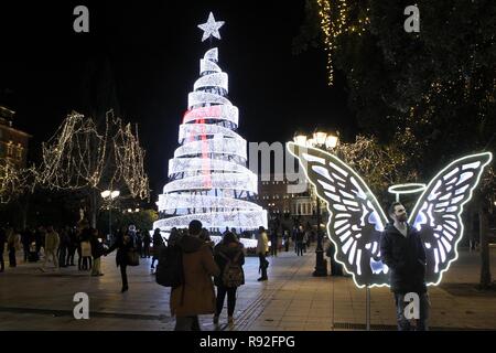 Athen, Griechenland. 18 Dez, 2018. Menschen gehen um einen beleuchteten Weihnachtsbaum auf dem Syntagma-Platz in Athen. (Bild: © aristidis VafeiadakisZUMA Draht) Stockfoto