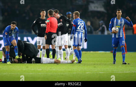 18. Dezember 2018, Berlin: Fussball: 1. Fussballbundesliga, 16. Spieltag, Hertha BSC - FC Augsburg im Olympiastadion Berlin: Martin Hinteregger aus Augsburg ist verletzt, nachdem eine Kopfzeile in der Behandlung auf dem Boden, im Hintergrund steht Kevin Danso aus Augsburg mit einem blauen Kopf verband. Foto: Andreas Gora/dpa - WICHTIGER HINWEIS: In Übereinstimmung mit den Anforderungen der DFL Deutsche Fußball Liga oder der DFB Deutscher Fußball-Bund ist es untersagt, zu verwenden oder verwendet Fotos im Stadion und/oder das Spiel in Form von Bildern und/oder Videos - wie Foto Sequenzen getroffen haben. Stockfoto