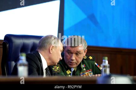 Moskau, Russland. 18. Dezember, 2018. Der russische Präsident Wladimir Putin spricht mit dem Chef der russischen Streitkräfte, General Valery Gerasimov, rechts, bei einem Treffen mit der militärischen Führung auf dem russischen Verteidigungsministerium Hauptsitz Dezember 18, 2018 in Moskau, Russland. Credit: Planetpix/Alamy leben Nachrichten Stockfoto