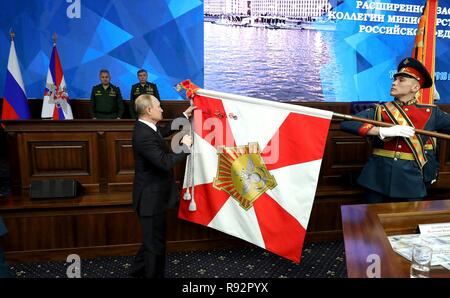 Moskau, Russland. 18. Dezember, 2018. Der russische Präsident Wladimir Putin den Stiften a regimental Flag während einer Zeremonie vor dem Treffen mit der militärischen Führung auf dem russischen Verteidigungsministerium Hauptsitz Dezember 18, 2018 in Moskau, Russland. Credit: Planetpix/Alamy leben Nachrichten Stockfoto