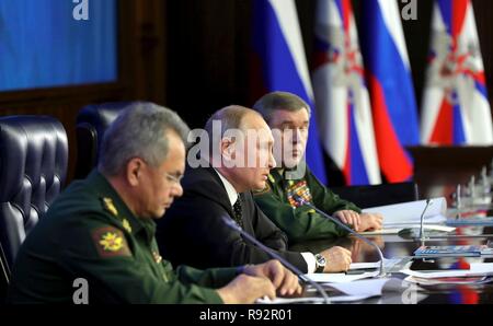 Moskau, Russland. 18. Dezember, 2018. Der russische Präsident Wladimir Putin, Mitte, liefert Erläuterungen neben Verteidigungsminister Sergej Shoigu, Links, und Chef der russischen Streitkräfte, General Valery Gerasimov, rechts, bei einem Treffen mit der militärischen Führung auf dem russischen Verteidigungsministerium Hauptsitz Dezember 18, 2018 in Moskau, Russland. Credit: Planetpix/Alamy leben Nachrichten Stockfoto