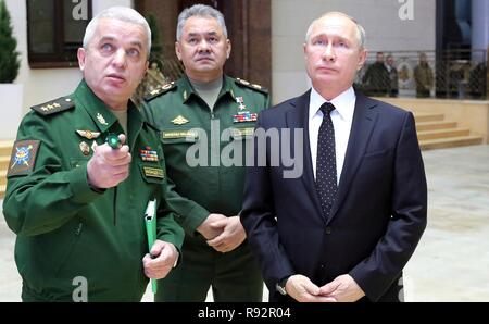 Moskau, Russland. 18. Dezember, 2018. Der russische Präsident Wladimir Putin, rechts, und Verteidigungsminister Sergej Shoigu, Zentrum, eine Ausstellung von Waffen aus syrischen Rebellen gefangen vor einem Treffen mit der militärischen Führung auf dem russischen Verteidigungsministerium Hauptsitz Dezember 18, 2018 in Moskau, Russland. Credit: Planetpix/Alamy leben Nachrichten Stockfoto