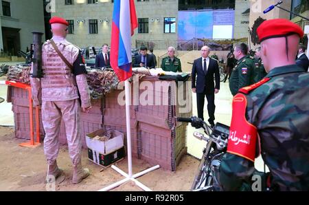 Moskau, Russland. 18. Dezember, 2018. Der russische Präsident Wladimir Putin, rechts, Blick eine Ausstellung von Waffen aus syrischen Rebellen gefangen vor einem Treffen mit der militärischen Führung auf dem russischen Verteidigungsministerium Hauptsitz Dezember 18, 2018 in Moskau, Russland. Credit: Planetpix/Alamy leben Nachrichten Stockfoto