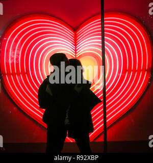 Die Oxford Street, London, 19. Dezember 2018. Ein paar Vor ein Herz Neon Licht Anzeige an John Lewis umfassen. Festliche Lichter und und bunten Fenster zeigt gehetzt Käufer in Kaufhäusern und Geschäften locken in der Oxford Street in London. Credit: Imageplotter Nachrichten und Sport/Alamy leben Nachrichten Stockfoto