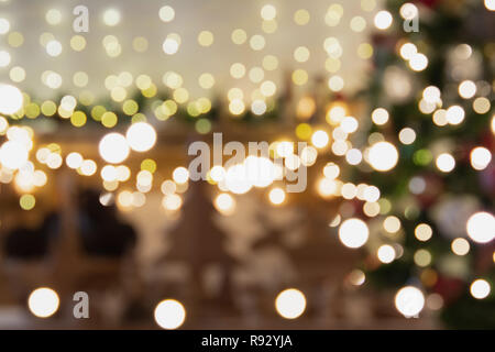 Abstrakte Komposition. Schöne verwischt Weihnachten Innenraum mit Kamin, Holz Kaminsims, beleuchteten Weihnachtsbaum, warmen Gelb- und bunten Lichtern, Kerzen, getönt Stockfoto