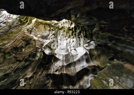 Sehr karstige Relief von Kalkstein mit weißlich-rötliche-grünlich Felsen erodiert. Löcher an der Decke lassen das Sonnenlicht geben Sie die Höhle von Cudugnon Stockfoto