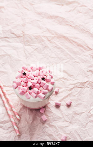 Heiße Schokolade oder Kakao mit Schlagsahne und Pink marshmallow Bonbons mit Zucker Schneeflocken und Schokolade Sterne mit Rosa gestreifte Trinkhalme auf c eingerichtet Stockfoto
