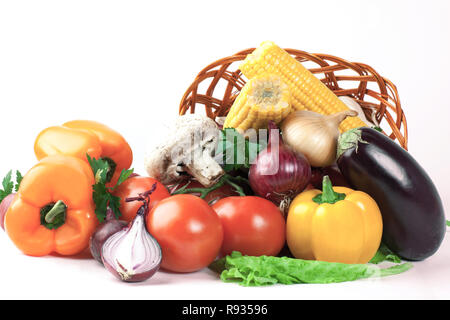 Pilze und eine Vielzahl von frischem Gemüse in einem Weidenkorb. Stockfoto