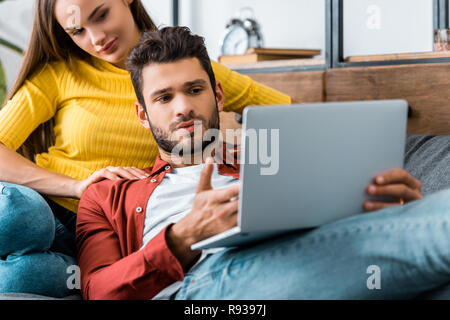 Junge konzentriert Paar saßen und am Laptop Stockfoto