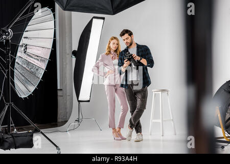 Junge Fotograf und Model checking Fotos auf der Kamera im Studio Stockfoto