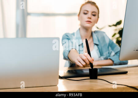 Schöne junge Frau Retoucher mit Grafiktablett im Büro Stockfoto