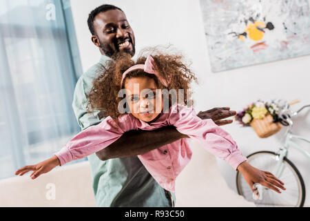 African American Dad spielt mit Tochter im Wohnzimmer Stockfoto