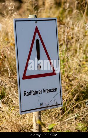 Warnschild, Schriftzug "Radfahrer kreuzen", Englisch für "Radfahrer kreuzen", Bikepark, Downhill Mountain Bike Trail am Stockfoto