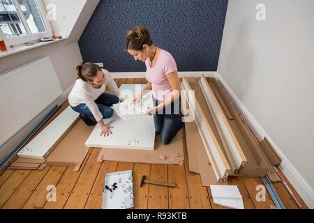 Mutter und Tochter gemeinsam ein Bett im Zimmer der Tochter zu montieren, Montage, Deutschland Stockfoto