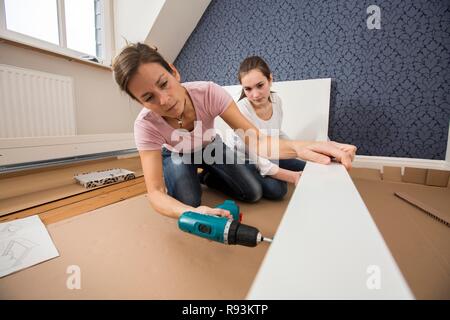 Mutter und Tochter gemeinsam ein Bett im Zimmer der Tochter zu montieren, Montage, Deutschland Stockfoto