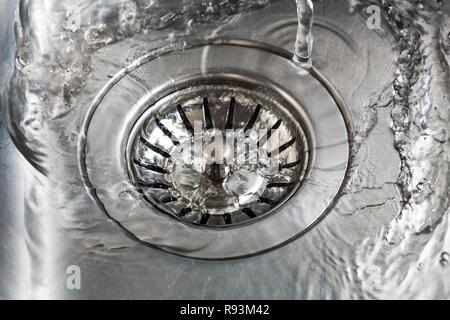 Wasser in den Abfluss der Spüle fließend, symbolische Bild für Wasserverbrauch, Wasserverschwendung Stockfoto