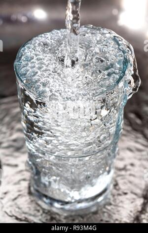 Wasser in einem Glas überfüllt Stockfoto