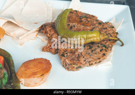 In der Nähe der Türkischen Papier Kebab (Kagit Kebap) serviert in einem weißen Teller mit Gemüse garnitures Stockfoto