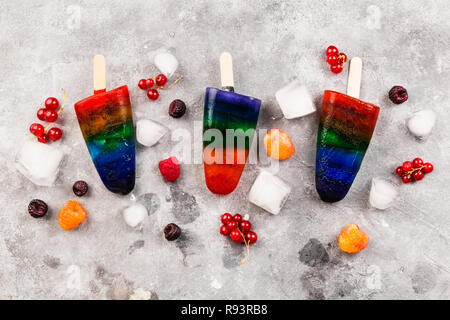 Rainbow Speiseeis popsicle auf grauem Hintergrund. Ansicht von oben. Essen Hintergrund Stockfoto