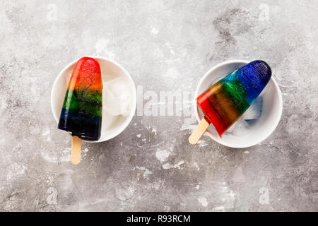 Rainbow Speiseeis popsicle auf grauem Hintergrund. Ansicht von oben. Essen Hintergrund Stockfoto