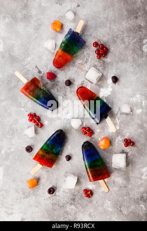 Rainbow Speiseeis popsicle auf grauem Hintergrund. Ansicht von oben. Essen Hintergrund Stockfoto
