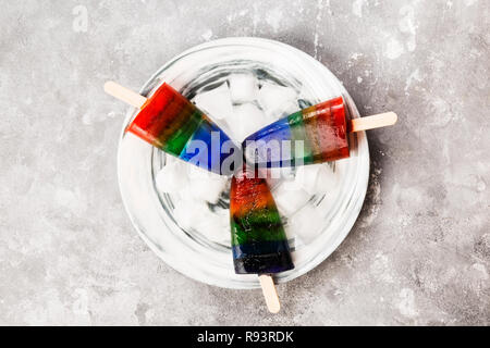 Rainbow Speiseeis popsicle auf grauem Hintergrund. Ansicht von oben. Essen Hintergrund Stockfoto