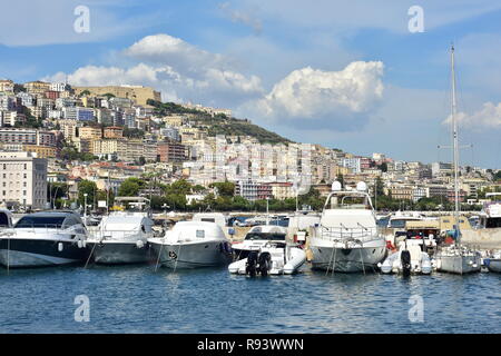 Freizeit Schiffe im Hafen von Marina mit dichten, urbanen Bereich gefüllt mit mediterranen Stil Apartment Gebäude auf einem Hügel im Hintergrund auf das Meer Küste Stockfoto