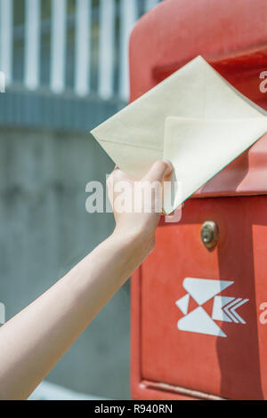 Einen Brief in den Briefkasten legen Stockfoto