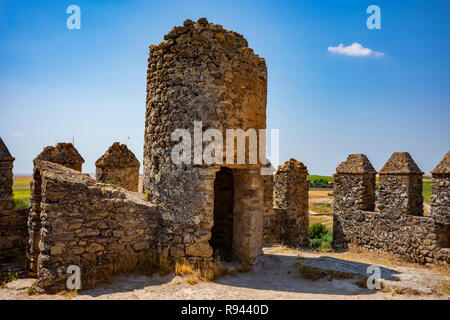 Die verlassenen Stein Aguzaderas Schloss in El Coronil, Spanien, eine Burgruine aus dem 14. Jahrhundert Morrish schloss, ruht in einem Feld mit Sonnenblumen in einer wolkenlosen, Summe Stockfoto