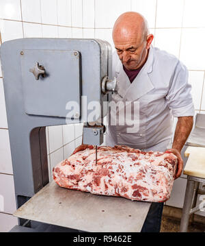 Männliche Metzger schneiden von Fleisch auf der Bandsäge bei Fleisch Fabrik Stockfoto