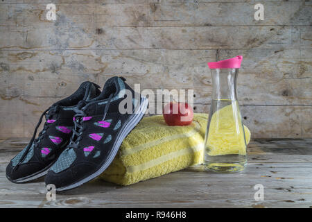 Konzept für Sport Training. Ein Paar Sportschuhe und einen Apfel zu essen und etwas Wasser zu trinken. Stockfoto