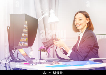 Portrait von glückliche Frau, professioneller Fotograf, Kamera und Computer Schreibtisch im Büro Stockfoto