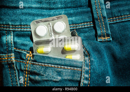 Pillen in Jeans pocket Nahaufnahme. Schutz der Gesundheit Konzept. Stockfoto