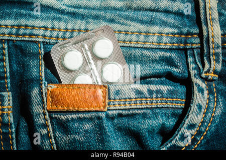 Pillen in Jeans pocket Nahaufnahme. Schutz der Gesundheit Konzept. Stockfoto