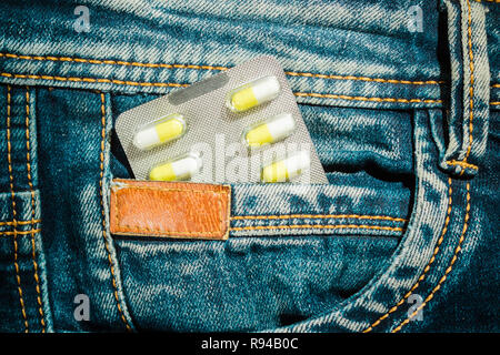 Pillen in Jeans pocket Nahaufnahme. Schutz der Gesundheit Konzept. Stockfoto